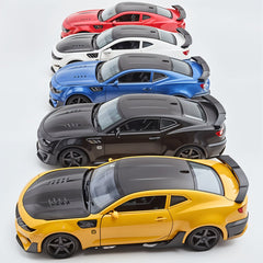 Four toy cars in different colors arranged in a row on a light gray background