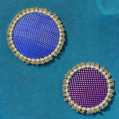 Two round coasters with blue and purple centers on a teal background