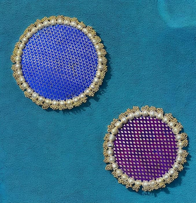 Two round coasters with blue and purple centers on a teal background