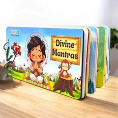 Children's book titled 'Divine Mantras' with colorful illustrations on a wooden surface.