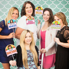 Five women posing with character-themed props against a patterned background
