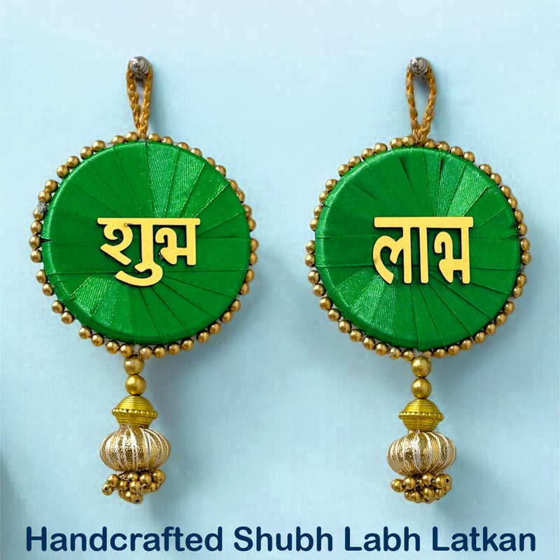 Handcrafted Shubh Labh Latkan earrings with green and gold design on a light blue background.