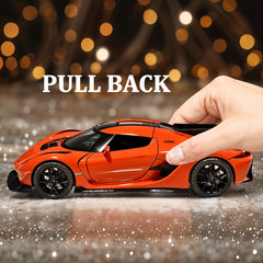 Orange toy car with a hand pulling it back against a blurred light background
