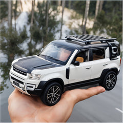 Model of a white SUV with black roof rack held in front of a scenic background