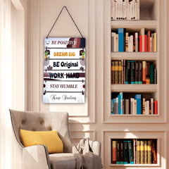 Decorative sign with motivational phrases in a room with a bookshelf and chair.