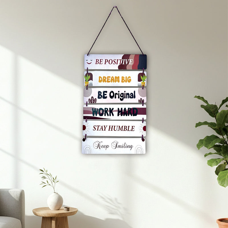 Motivational poster with inspirational quotes on a wall in a bright room with plants and a side table.