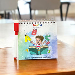 Children's educational book on a wooden table with chairs in the background