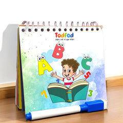 Children's educational book with colorful illustrations and a marker on a wooden surface