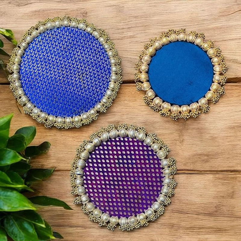 Three decorative coasters with blue, purple, and gold patterns on a wooden surface.