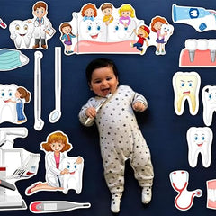 Baby lying on a dark blue surface surrounded by dental-themed illustrations and toys.