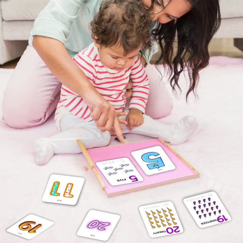 Woman and child playing with educational cards on a pink mat