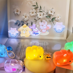 Colorful keychains shaped like cartoon characters on a surface with flowers in the background.