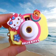 Colorful Hello Kitty camera held by a hand with a beach background