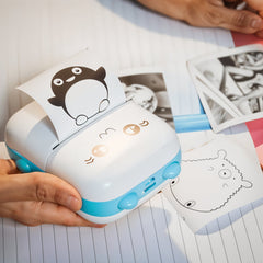 Small printer with cartoon design on a piece of paper, held by a person.