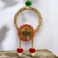 Decorative wall hanging with gold, red, and green elements on a wooden surface.