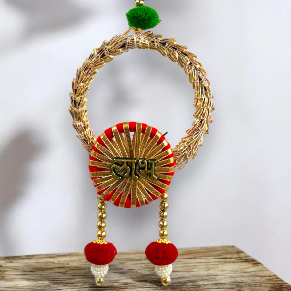 Decorative wall hanging with gold, red, and green elements on a wooden surface.