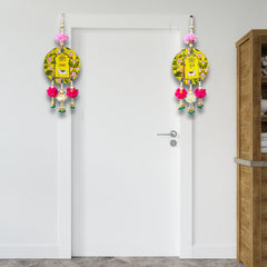 Decorative items hanging on a white door with a wooden cabinet in the background.