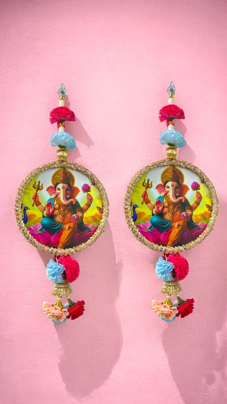 Colorful earrings with a deity design on a pink background