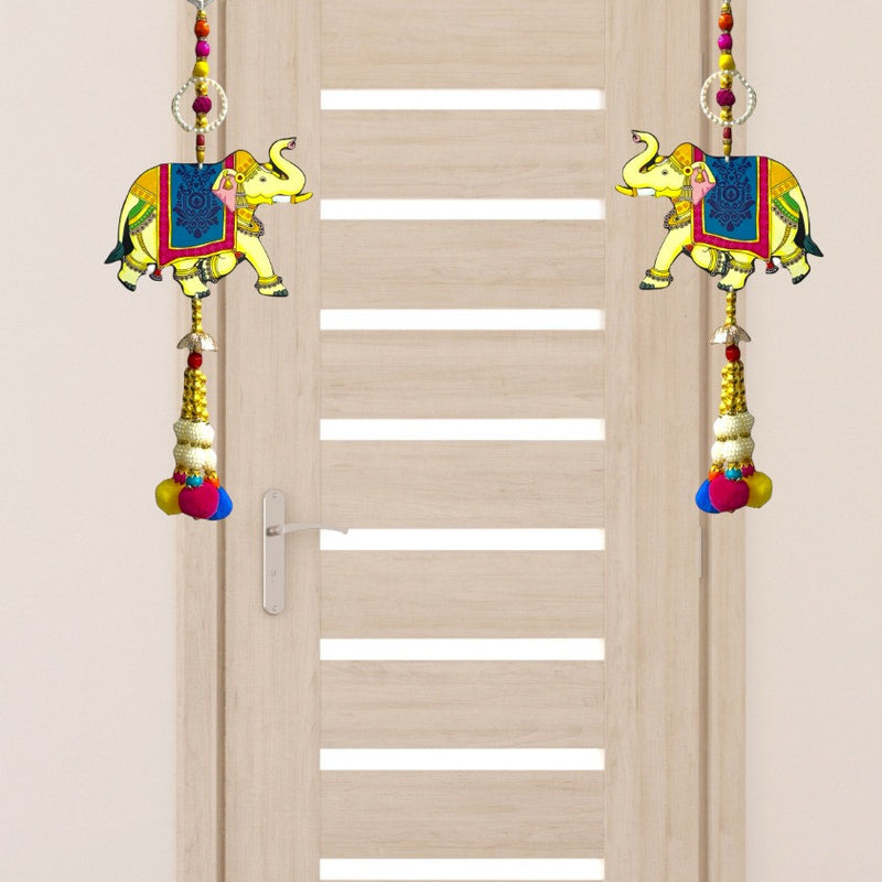 Decorative elephant door hanging on a wooden door with a plain wall background