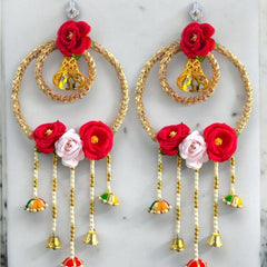 Decorative earrings with red and pink flowers on a marble surface
