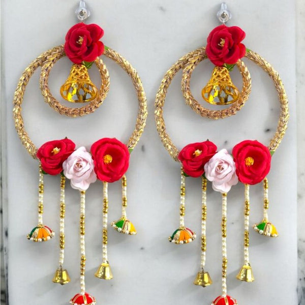 Decorative earrings with red and pink flowers on a marble surface