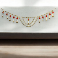 Decorative garland with red and gold elements on a neutral background