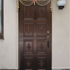 Decorative door with gold and pink decorations on a building exterior.
