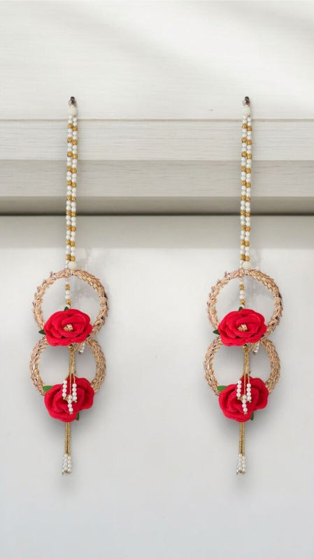 Pair of earrings with red floral elements on a white background
