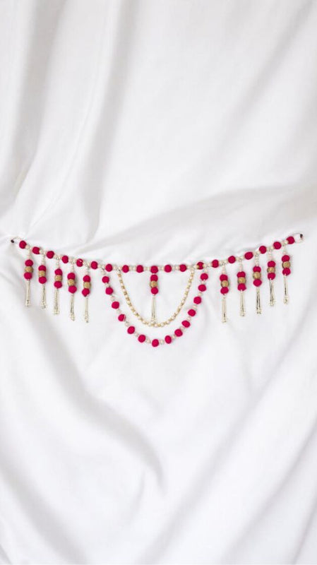 White fabric with red and gold beaded embellishments on a white background