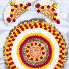 Decorative round rangoli with yellow, pink, and white patterns on a white background