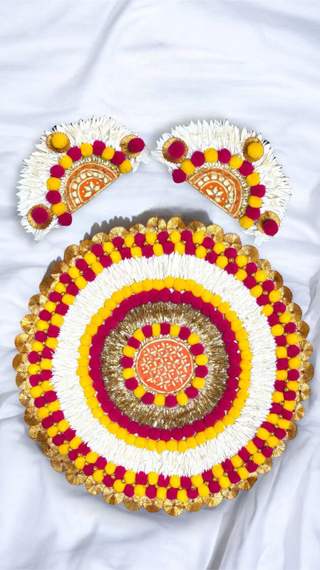 Decorative round rangoli with yellow, pink, and white patterns on a white background