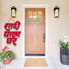 Decorative red sign on a door with flowers and plants around