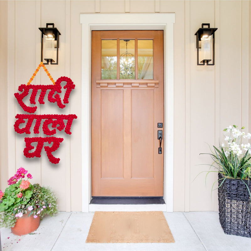 Decorative red sign on a door with flowers and plants around