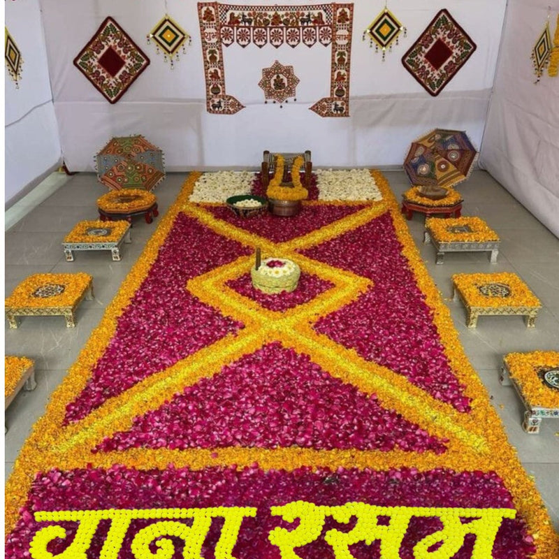Decorative setup with a large flower arrangement in the shape of a diamond, surrounded by smaller tables and decorations.