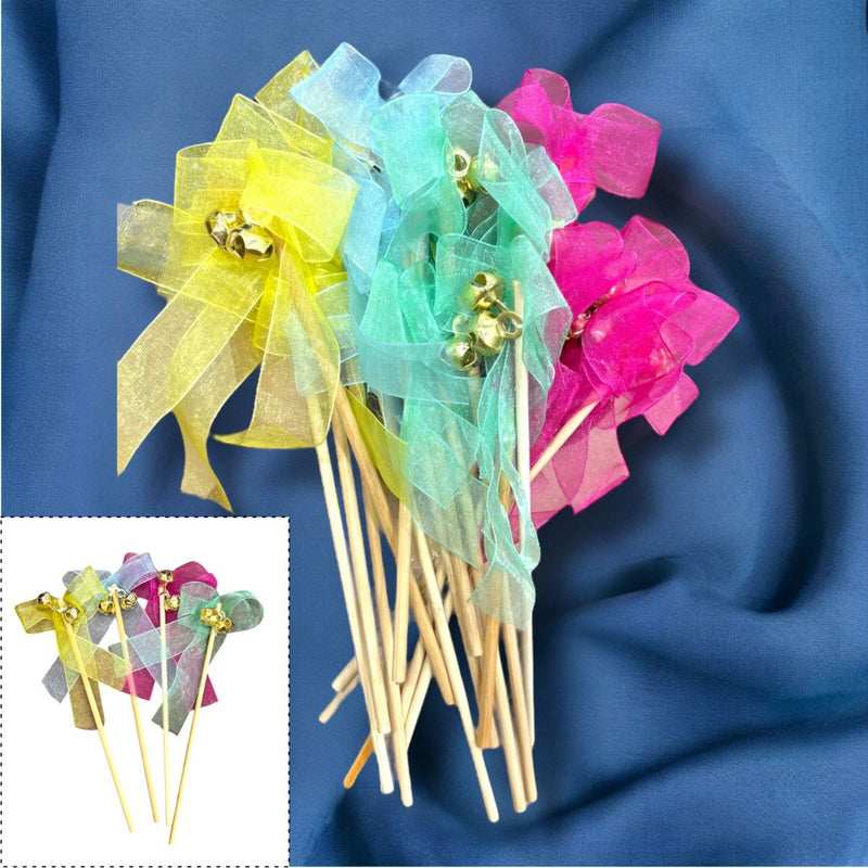Colorful party wands with ribbons and bells on a blue fabric background
