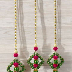 Pair of earrings with pink and green beads on a white background