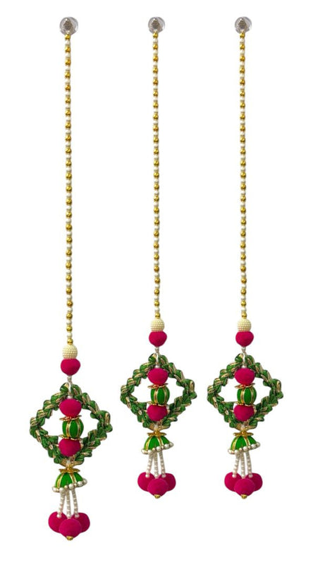 Set of three decorative hanging earrings with green, pink, and gold elements on a white background.