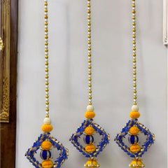 Decorative hanging elements with blue and yellow beads on a white wall.