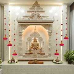 Decorative wall with Buddha statue and floral arrangements in a well-lit room.