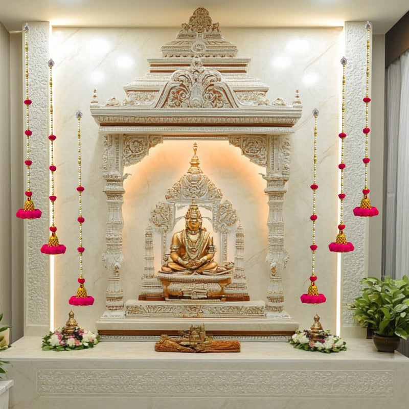Decorative wall with Buddha statue and floral arrangements in a well-lit room.