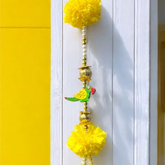 Decorative yellow pom-pom hanging on a white door with a yellow wall background