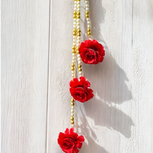 Necklace with red floral pendants and gold beads on a white background