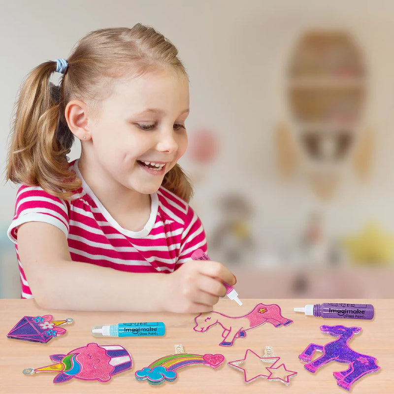 Child engaged in arts and crafts with colorful stickers and markers on a table.